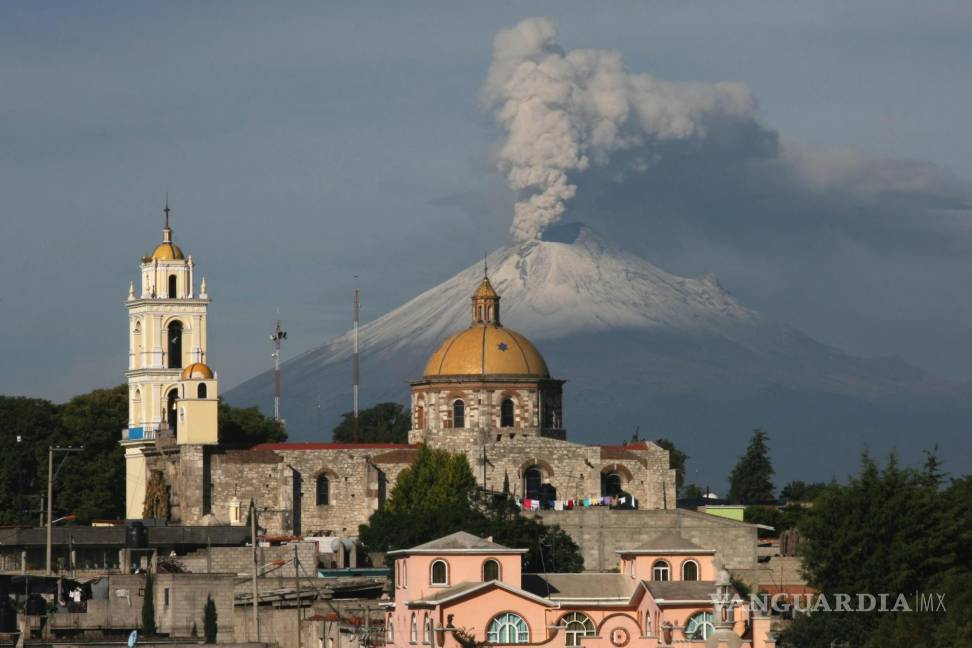 $!La iglesia principal de San Damián Texoloc, Tlaxcala, en México, al frente del volcán Popocatépetl mientras expulsa cenizas y vapor a inicios de julio de 2013.