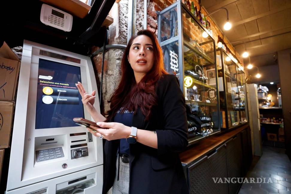 $!La cofundadora del Bitcoin Embassy Bar, Lorena Ortiz, muestra el funcionamiento de un cajero automático de bitcoin en Ciudad de México. EFE/José Méndez