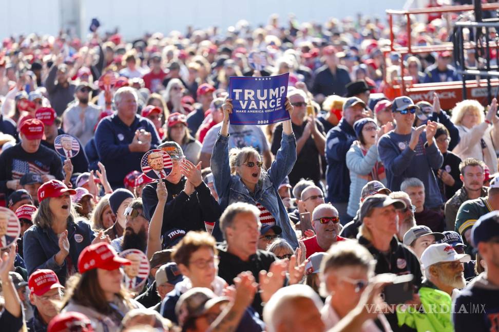 $!Partidarios escuchan al candidato presidencial republicano Donald Trump en un mitin de campaña en el aeropuerto del condado de Dodge en Juneau, Wisconsin.