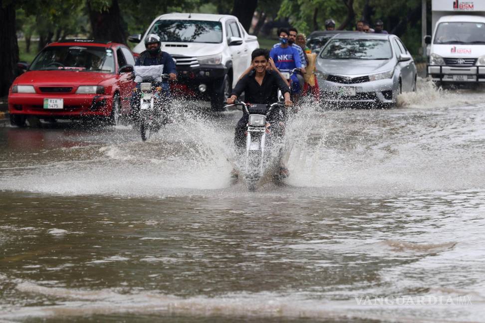 $!La gente circula por las calles inundadas durante las fuertes lluvias en Lahore, Pakistán, el 19 de septiembre de 2023.