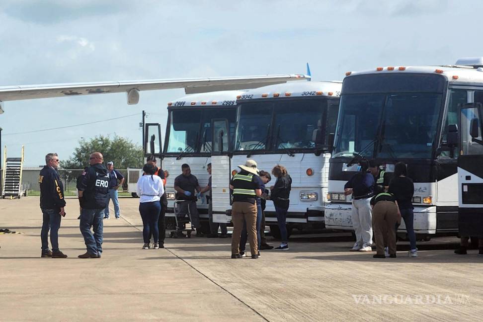 $!Oficiales de migración mientras requisan a unos migrantes antes de ser deportados en grupo en el Aeropuerto de Harlingen.