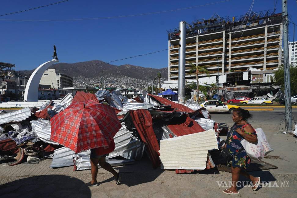 $!Residentes caminan junto a escombros tras la devastación que dejó el paso del huracán Otis, en Acapulco, México, el domingo 12 de noviembre de 2023.
