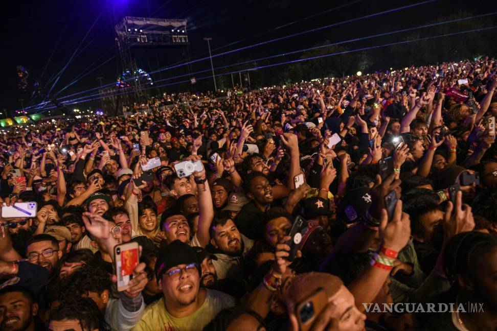 $![a los otros asistentes. The crowd watches as Travis Scott performs at Astroworld Festival at NRG park on Friday]