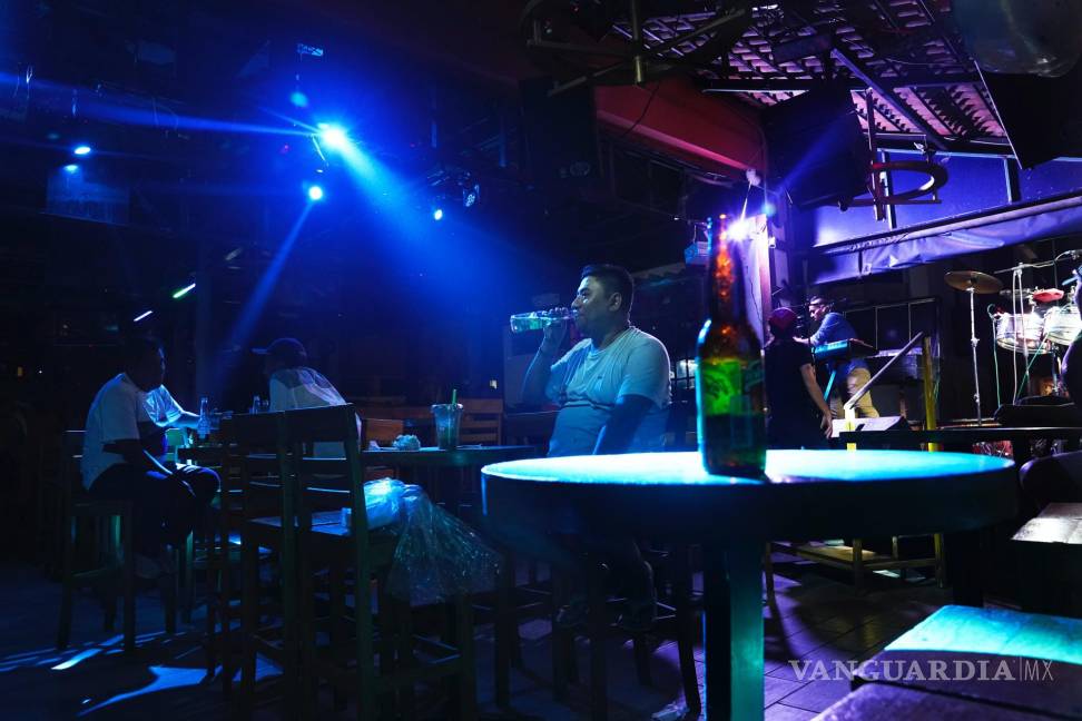 $!Los clientes beben cervezas en un bar a lo largo del bulevar costero que atraviesa la zona hotelera después del huracán Otis, en Acapulco, México.