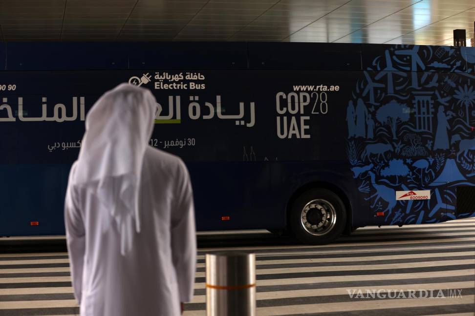 $!Un hombre se para frente a un autobús con el logotipo de la COP28 en Dubai, Emiratos Árabes Unidos.