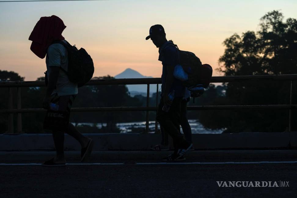 $!Con el volcán Tajumulco al fondo, migrantes caminan por la carretera de Huixtla con la esperanza de llegar a la frontera norte del país y, eventualmente, a EU.