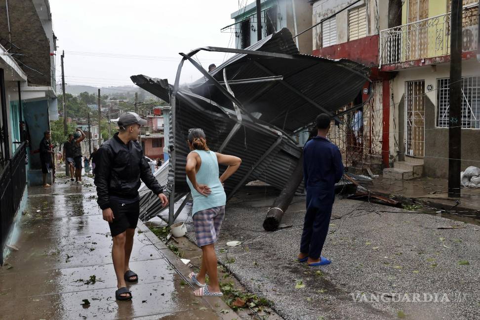 $!Personas caminan por una calle afectada por el paso del huracán Melissa en Santiago de Cuba.