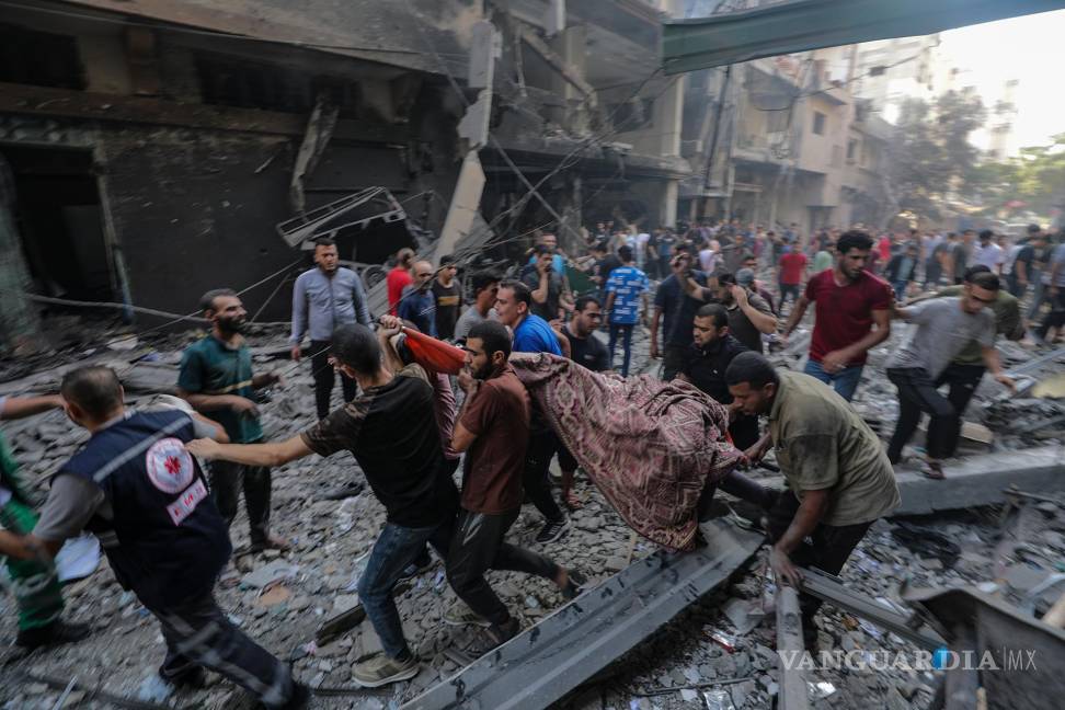 $!Tras un ataque en la comunidad de Al-Shati, al oeste de Ciudad de Gaza, algunos palestinos remueven el cuerpo de una víctima.