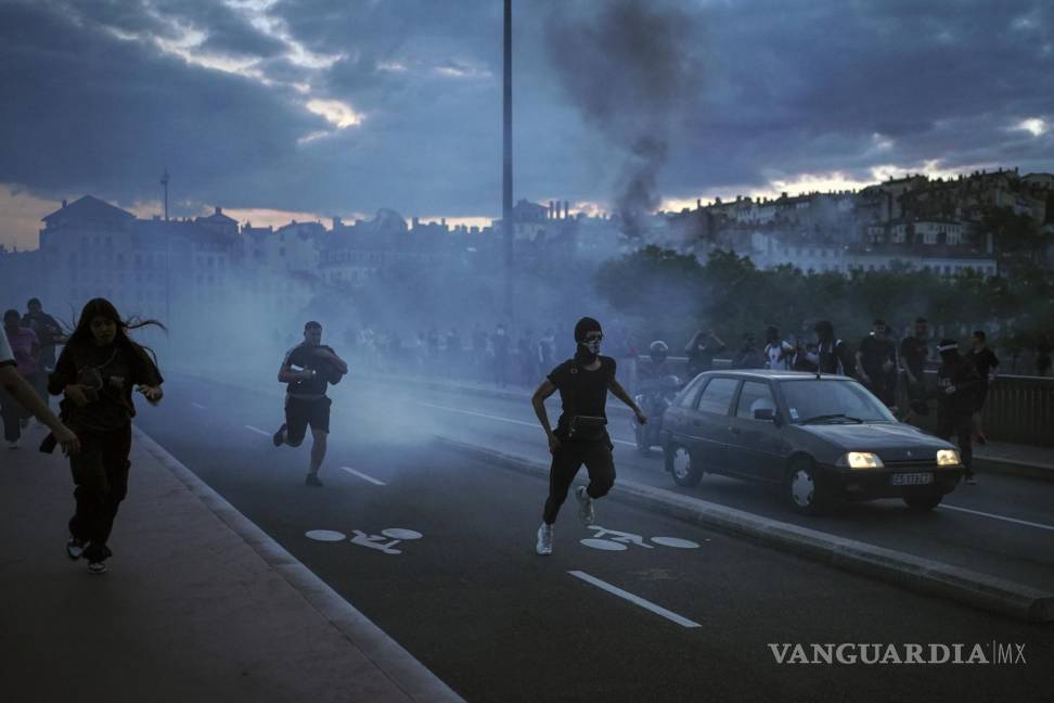 $!Varias personas salen corriendo durante disturbios con la policía en el centro de Lyon.