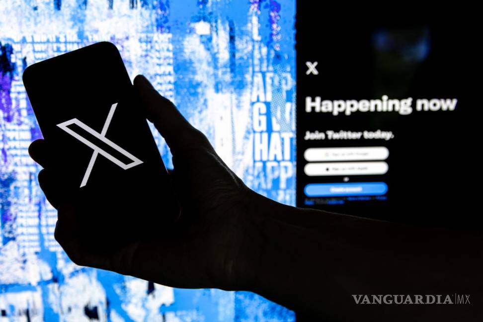 $!Un usuario mientras sostiene un teléfono móvil que muestra el logotipo 'X' frente a la página principal de Twitter, el 28 de julio de 2023 en Los Ángeles, California.