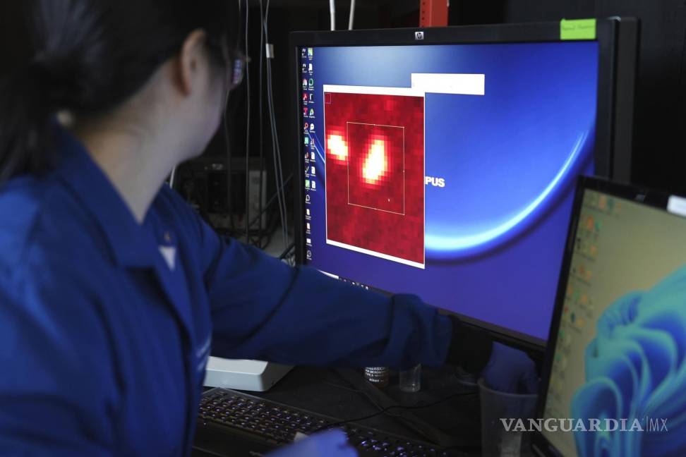 $!Naixin Qian amplía una imagen generada a partir de un escaneo microscópico, con nanoplásticos que aparecen como puntos rojos brillantes en Nueva York.