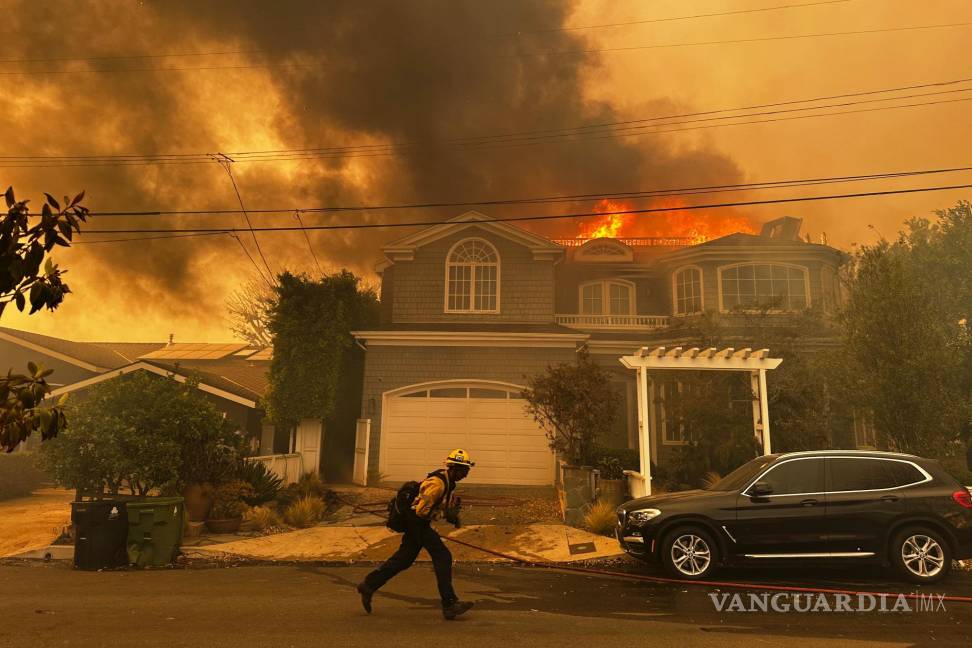 $!Una residencia en llamas mientras un bombero combate un incendio en Pacific Palisades, el martes 7 de enero de 2025, en Los Ángeles.