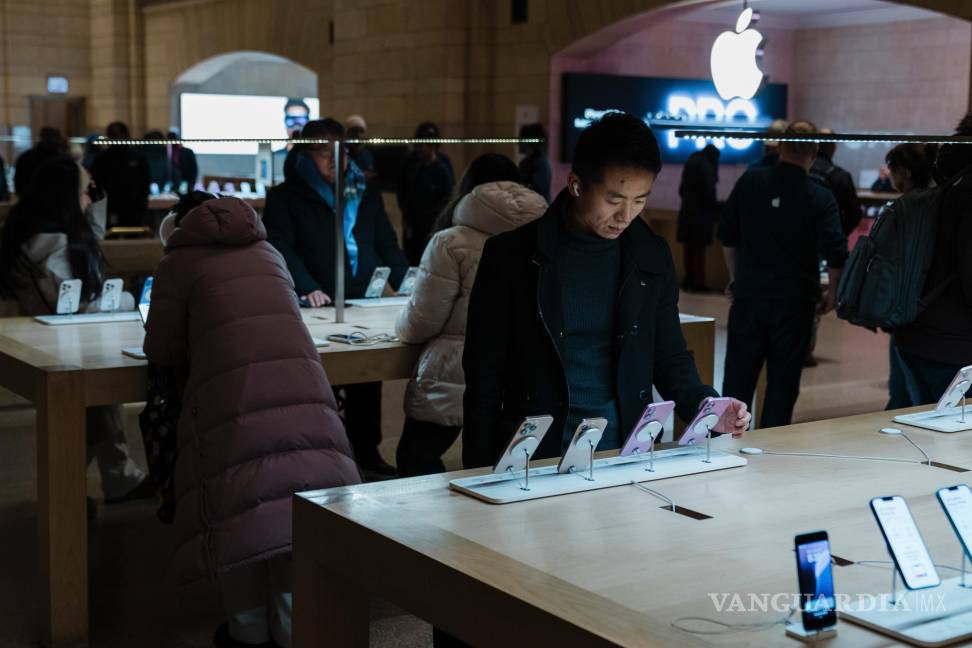 $!Un cliente examina el último modelo de iPhone en la Apple Store de Grand Central Terminal en Nueva York tras cuatro meses de su segundo mandato, hay indicios de que la economía comienza a sufrir mayores tensiones.