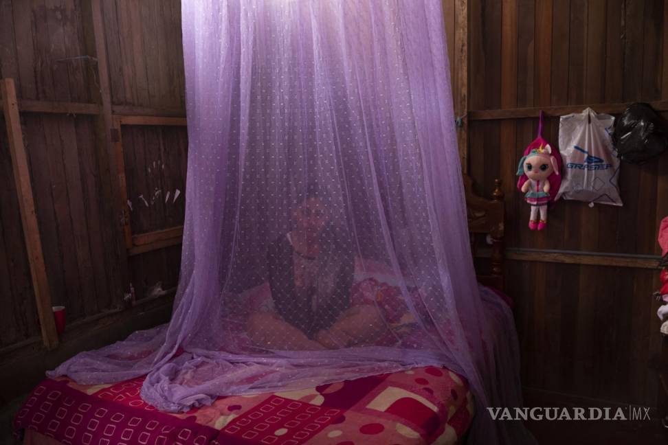 $!En esta fotografía de archivo del martes 29 de septiembre de 2020, Valentina Esperanza, que se recupera de dengue, permanece sentada en su cama protegida con un mosquitero mientras ve un programa de televisión en su casa en la ciudad de Pucallpa, departamento de Ucayali, en Perú. AP/Rodrigo Abd