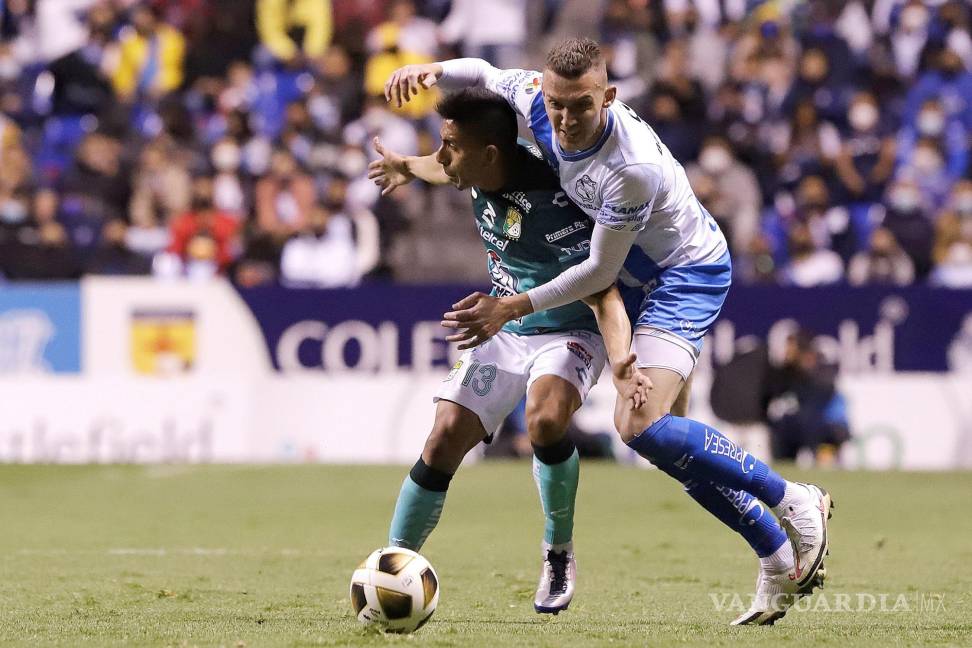 $!Lucas Jaques (d) de Club Puebla disputa el balón con Angel del futbol mexicano, en el estadio Cuauhtémoc de la ciudad de Puebla. Mena (i) de León durante un juego de ida de los cuartos de final del Torneo Apertura 2021 de la Liga MX