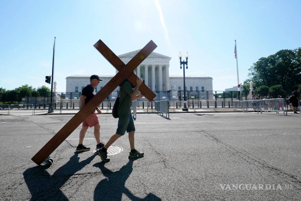 $!Una persona lleva una cruz frente a la Corte Suprema en Washington.