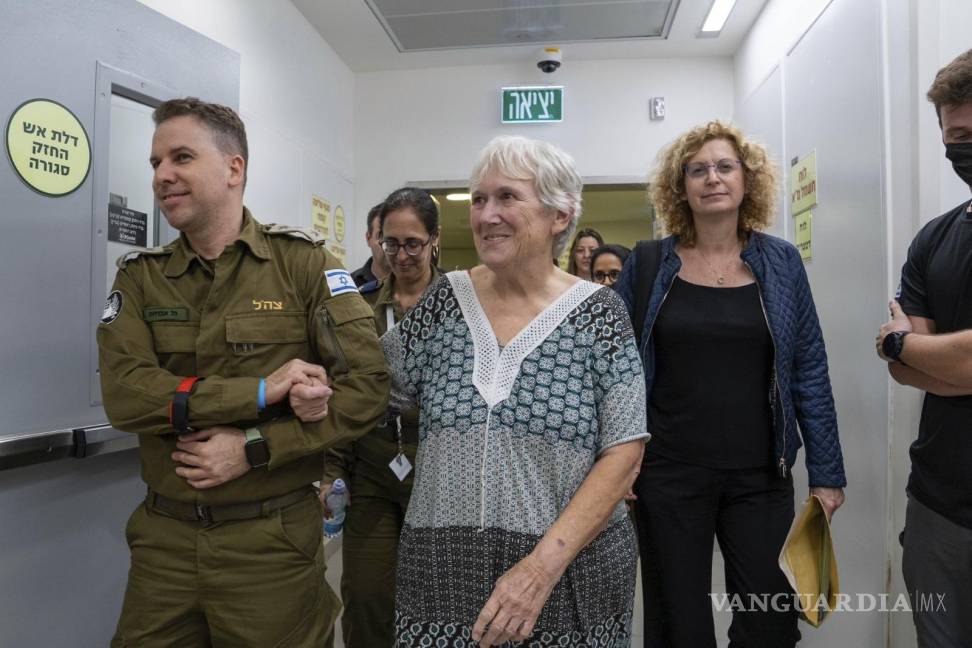 $!Margalit Mozes, una rehén israelí liberada, camina con un soldado israelí poco después de su llegada a Israel el viernes 24 de noviembre de 2023.
