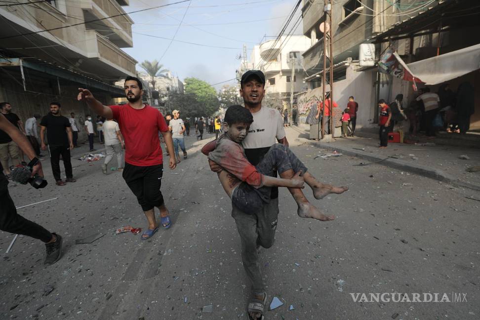 $!Un palestino carga a un niño herido tras un ataque aéreo israelí en el norte de Gaza.