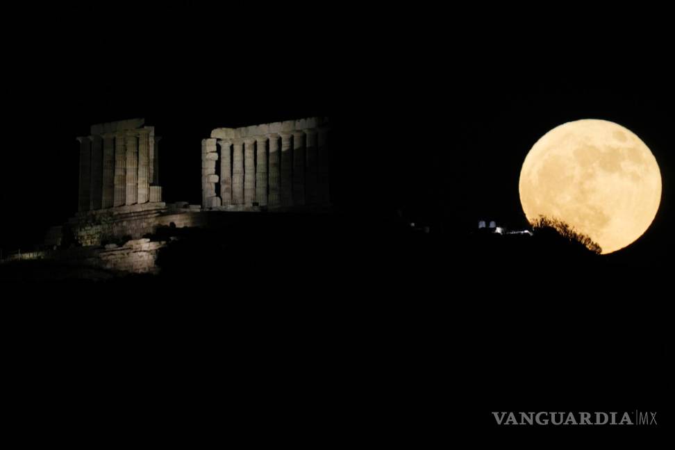 $!La luna llena de fresas se eleva detrás del antiguo templo de Poseidón en el cabo Sounion al sur de Atenas, Grecia.