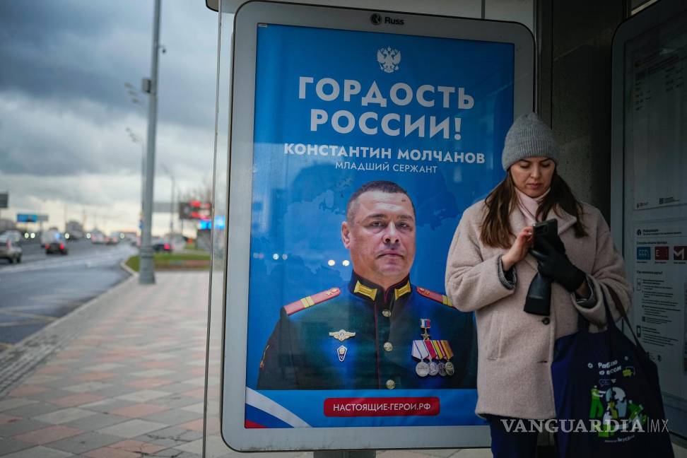 $!Una mujer en una parada de autobúscon un cartel que dice “Orgullo de Rusia” que muestra a un soldado ruso de la operación militar en Ucrania, en Moscú, Rusia.