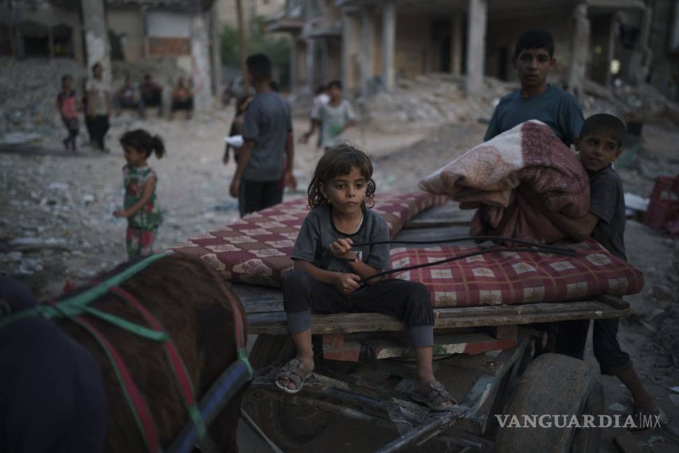 $!Chadi Nassir, de 7 siete años, se sienta en un carro tirado por un burro mientras su hermano, Mahmoud, lo carga con pertenencias recuperadas de su casa dañada en Beit Hanoun, en el norte de la Franja de Gaza, el domingo 13 de junio de 2021. AP/Felipe Dana