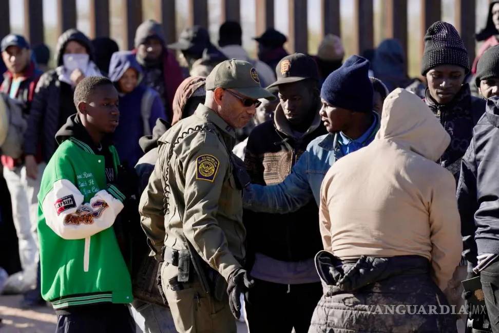 $!Un miembro de la Oficina de Aduanas y Protección Fronteriza intenta controlar a un grupo de migrantes el martes 5 de diciembre de 2023 en Lukeville, Arizona.