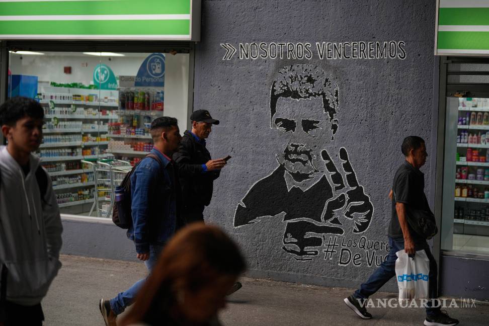 $!Personas pasan junto a un mural del expresidente venezolano Nicolás Maduro con la frase ‘Venceremos’ en Caracas, Venezuela.