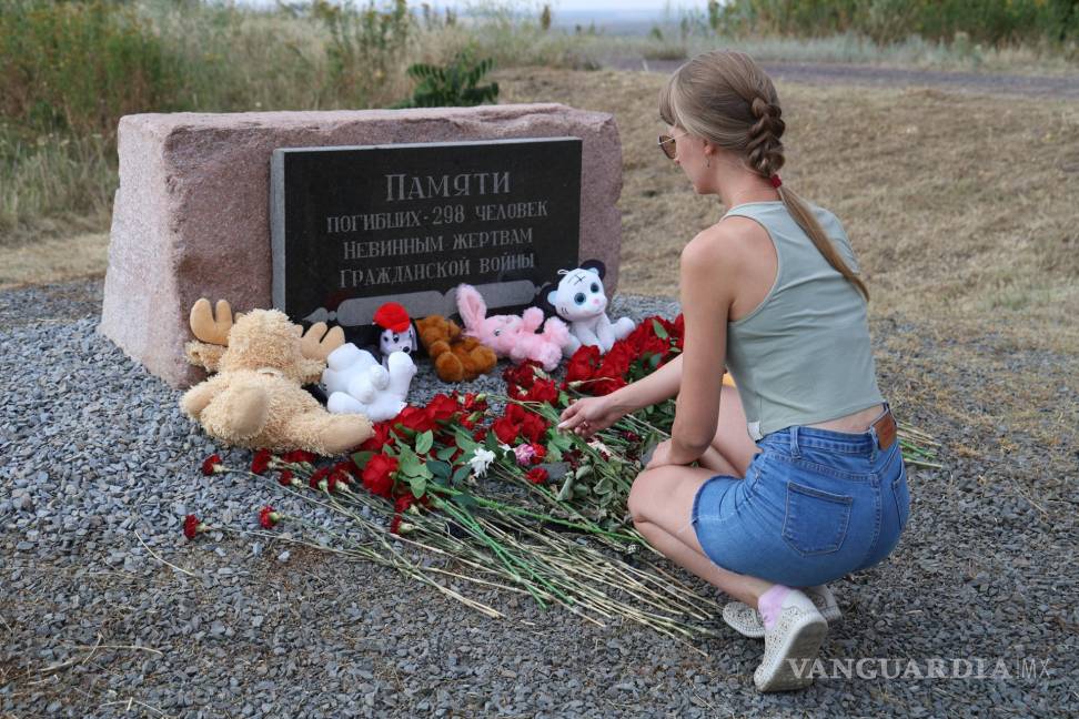$!Una mujer deposita flores en el monumento a las víctimas durante una ceremonia de luto en el lugar del accidente del avión MH17.
