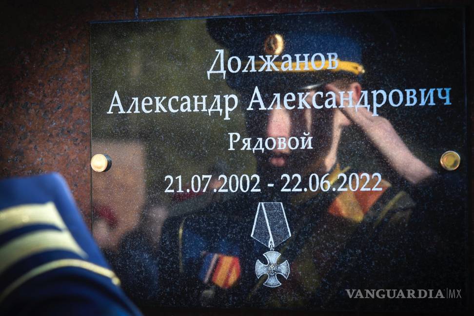 $!Un estudiante de una escuela militar saluda de pie frente a una placa con el nombre del soldado ruso Alexander Dolzhanov, quien murió en Ucrania.