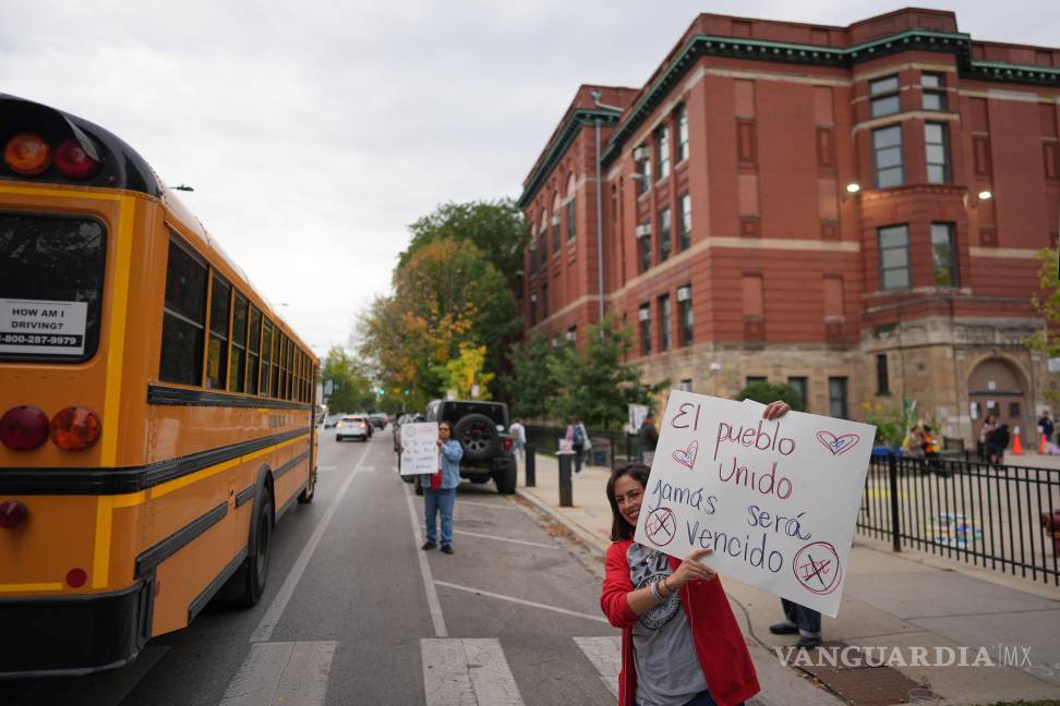 $!La maestra de primer grado, María Heavener, con un cartel que dice en español: “El pueblo, unido, jamás será vencido”, en el barrio de Logan Square de Chicago.