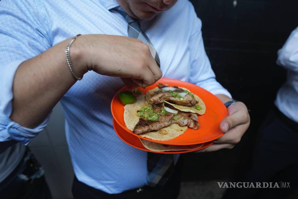 $!Un cliente exprime un limón en sus tacos en la taquería Tacos El Califa de León en Ciudad de México.