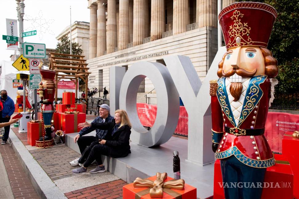 $!Una pareja frente a un cartel de ‘Joy’ para tomarse fotografías en un mercado navideño al aire libre en Washington, DC. EFE/EPA/Michael Reynolds