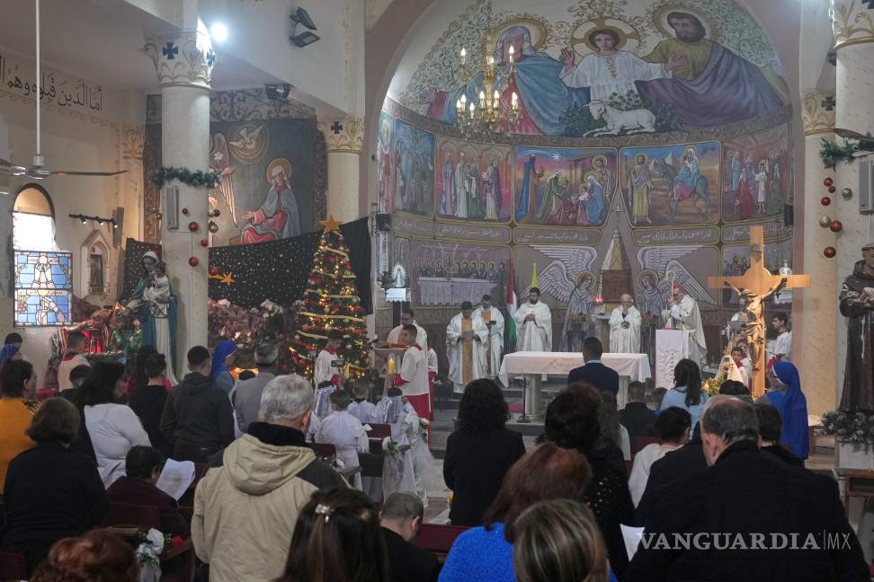 $!Parroquianos palestinos asisten a una misa liderada por el cardenal Pierbattista Pizzaballa antes de las celebraciones navideñas en Ciudad de Gaza.
