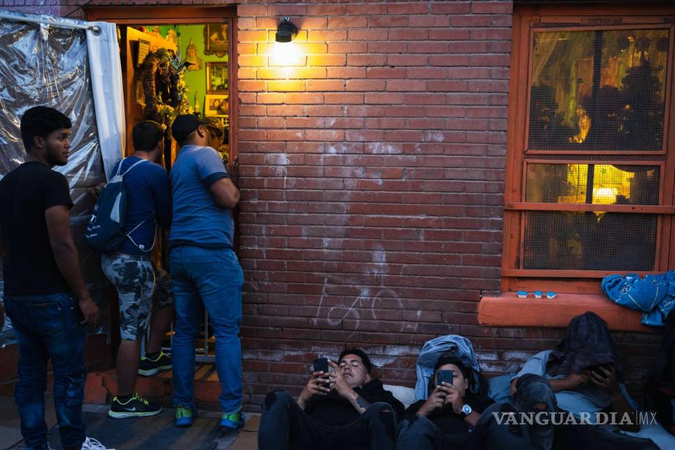 $!Migrantes afuera de un apartamento donde pueden pagar 1 dólar para cargar sus teléfonos, en El Paso, Texas.