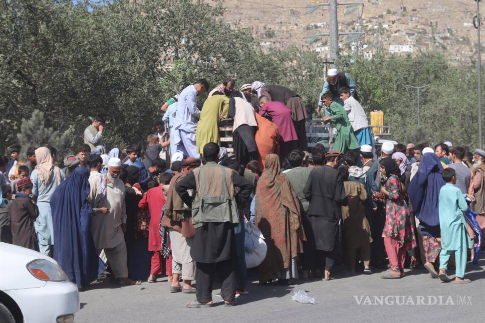 $!Afganos que son desplazados de las provincias de Kunduz y Takhar debido a los combates entre las fuerzas talibanes y afganas se reúnen para recolectar alimentos, ya que viven en refugios temporales en un campamento en Kabul, Afganistán. EFE/EPA