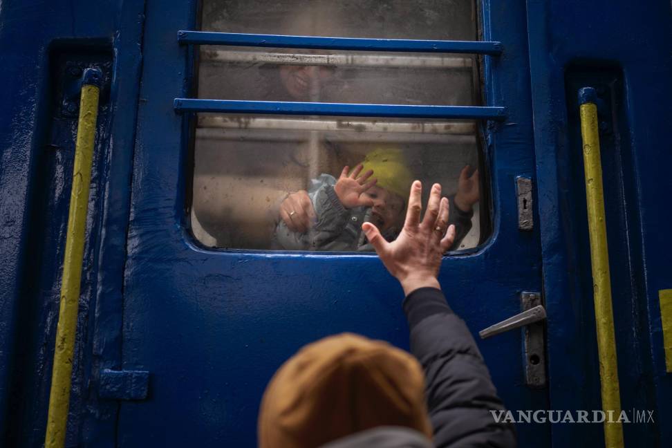 $!Stanislav se despide de su hijo de dos años David y de su esposa Anna luego de que embarcasen en un tren que los llevaría a Leópolis, en la estación de Kiev, Ucrania.