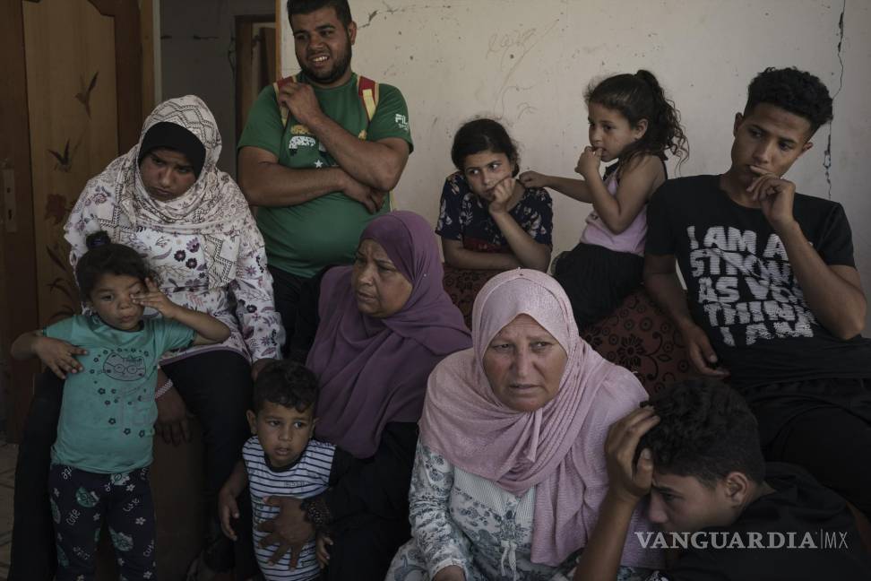 $!Khaldiya Nassir, en el centro a la izquierda, se sienta con otros familiares cerca de la entrada de su casa, muy dañada por los ataques aéreos de la última guerra de 11 días en Beit Hanoun, en el norte de la Franja de Gaza, el domingo 13 de junio de 2021. AP/Felipe Dana