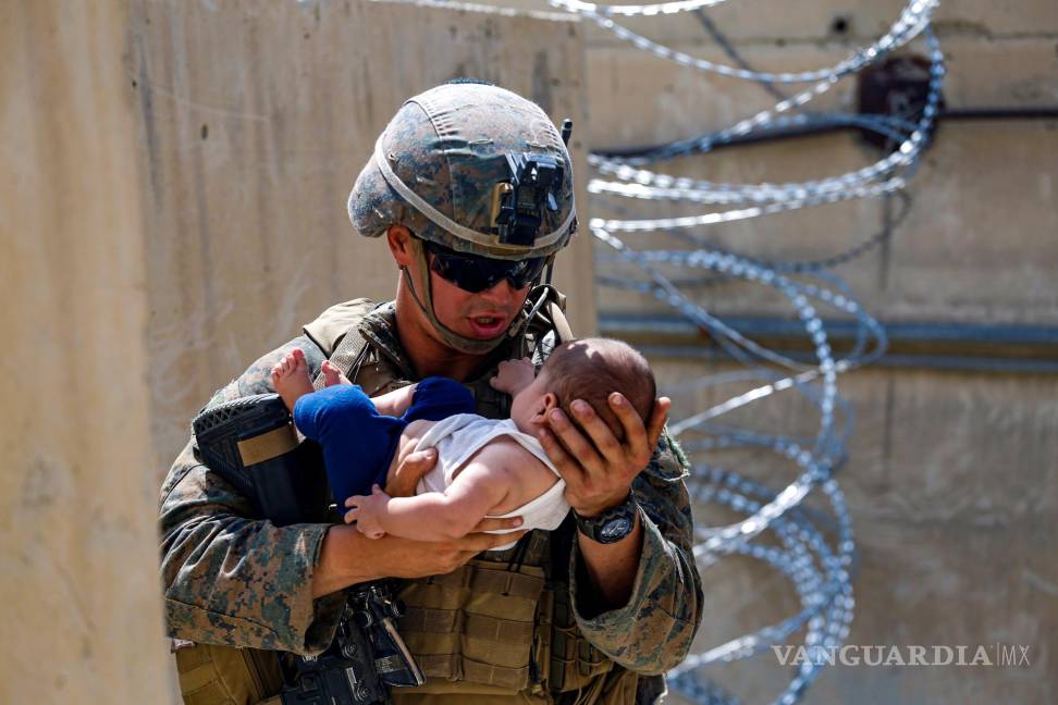 $!Un infante de marina de los Estados Unidos asignado a la 24a Unidad Expedicionaria de los Infantes de Marina (MEU) consuela a un bebé mientras esperan a la madre durante una evacuación en el Aeropuerto Internacional Hamid Karzai, en Kabul, Afganistán. EFE/EPA/U.S. Marine Corps/Lance Cpl. Nic