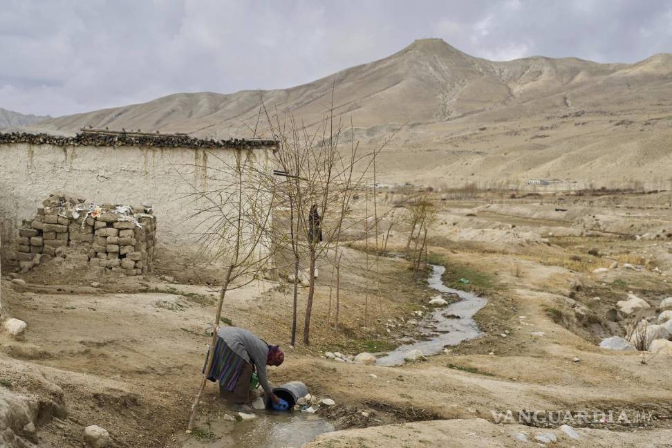 $!Una mujer recolecta agua en el asentamiento recién reubicado del poblado abandonado de Samjung, en la región de Mustang al oeste de Katmandú, Nepal.