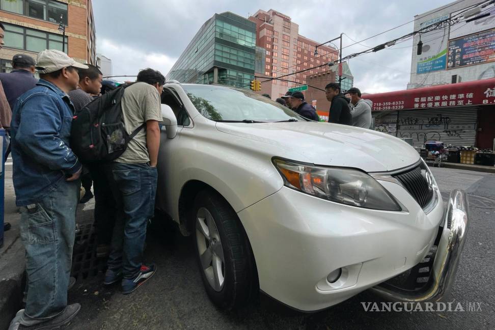 $!Wang Gang, de 36 años, centro izquierda, inmigrante chino, conversa con el conductor de un coche para conseguir un trabajo en el barrio de Flushing.