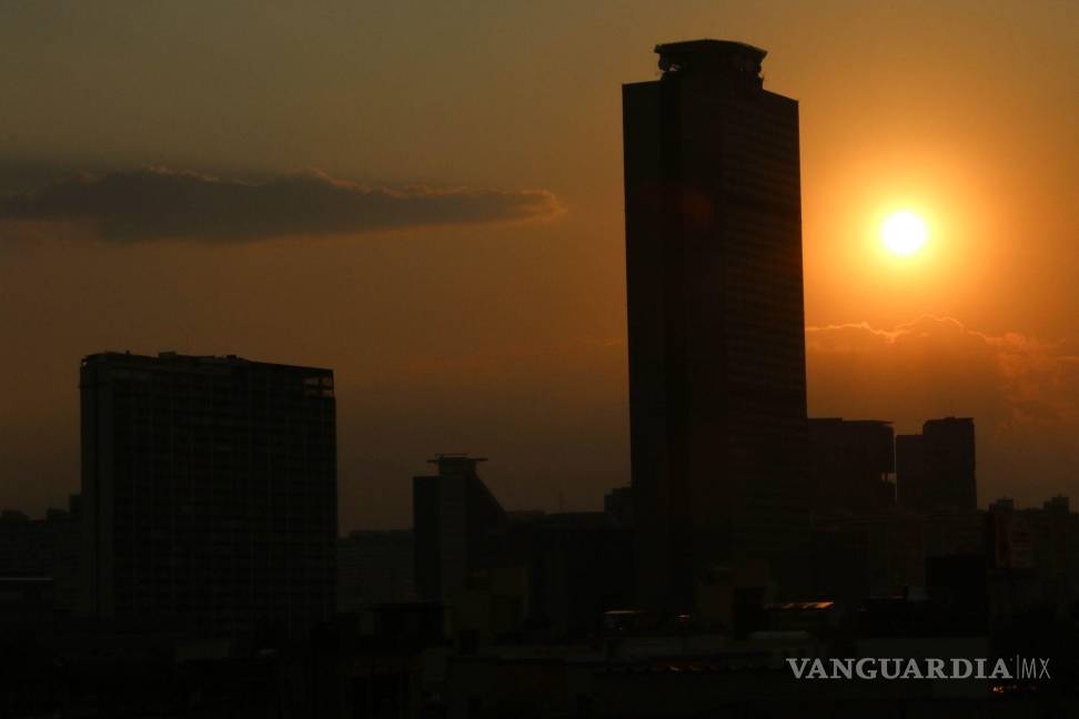 $!Tarde de contraste en la capital en dónde por momentos hubo lluvia, arcoiris y un espectacular atardecer. En la imagen se observa la silueta de la Torre de Pemex.