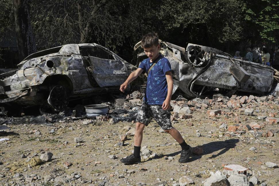 $!Autos dañados yacen en un patio entre otros escombros después de un ataque con aviones no tripulados y misiles rusos en Kiev, Ucrania.