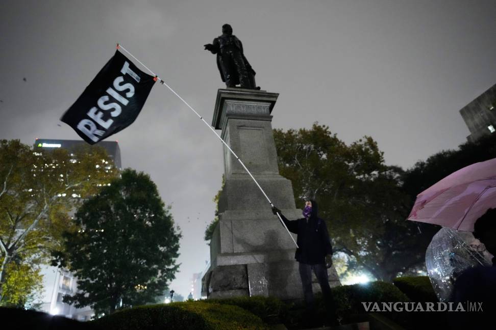 $!Un manifestante bajo una lluvia torrencial durante una protesta contra la inminente ofensiva de la CBP contra la inmigración ilegal en Nueva Orleans.