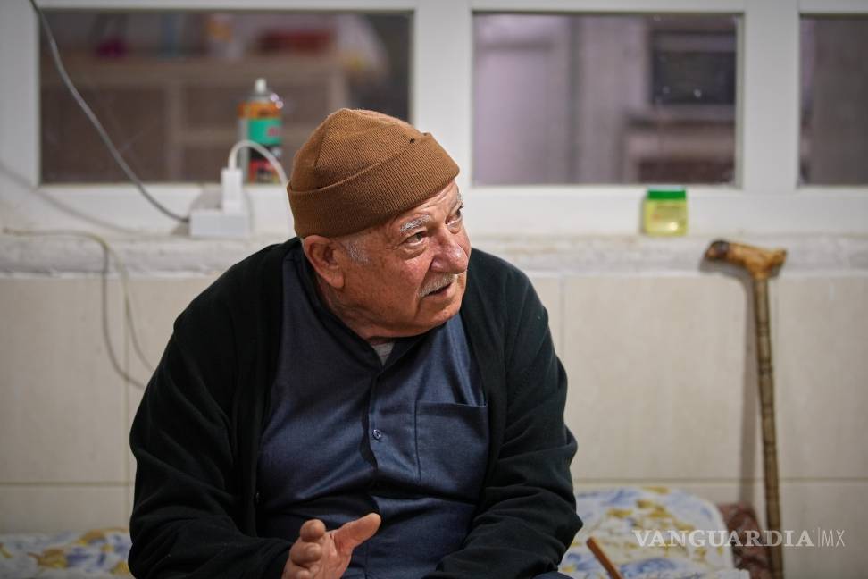$!El refugiado sirio Abdullah Amin Dawood, de 73 años, se sienta en la sala de estar de su casa en Erbil, Irak, el 16 de noviembre de 2025.