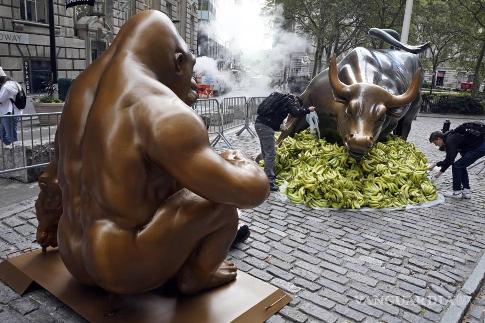 $!Una estatua de Harambe, el gorila del zoológico de Cincinnati, se enfrenta al “Charging Bull” de Arturo Di Modica, rodeado de plátanos, en el distrito financiero de Nueva York. AP/Richard Drew