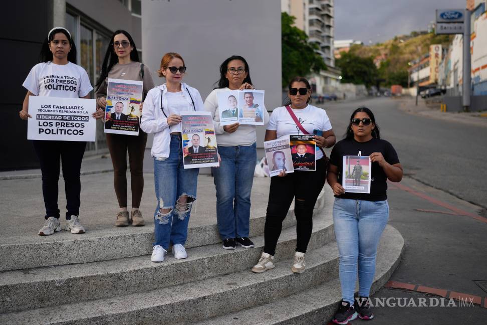$!Familiares de detenidos sostienen carteles cerca de El Helicoide, sede del servicio de inteligencia venezolano y centro de detención, en Caracas, Venezuela.