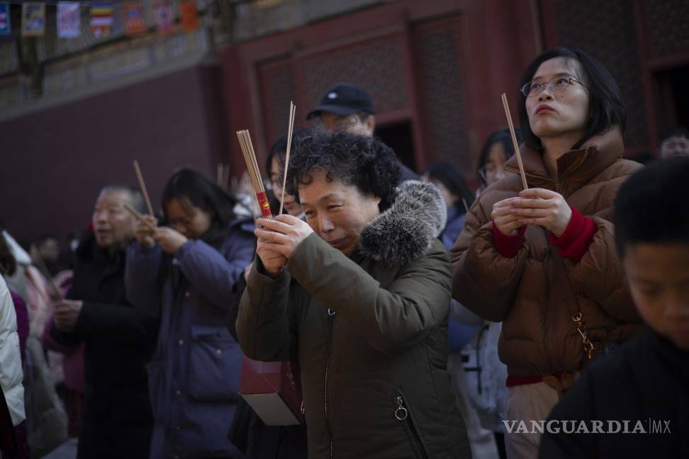 $!Los fieles que sostienen varitas de incienso rezan en el primer día del Año Lunar del Dragón en el Templo Yonghegong Lama en Beijing, China.
