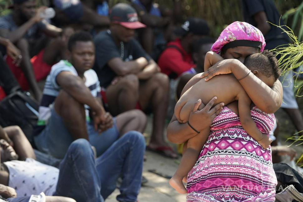 $!Una mujer migrante sostiene a su hijo mientras espera en un campamento improvisado con otros después de cruzar el Río Bravo hacia los Estados Unidos desde México en Del Río, Texas. AP/Eric Gay