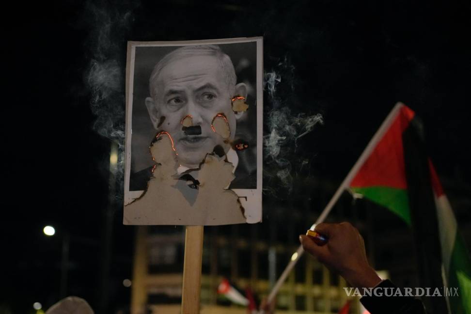 $!Manifestantes queman una fotografía del primer ministro israelí, Benjamin Netanyahu, en una manifestación frente a la embajada de Israel en Atenas, Grecia.
