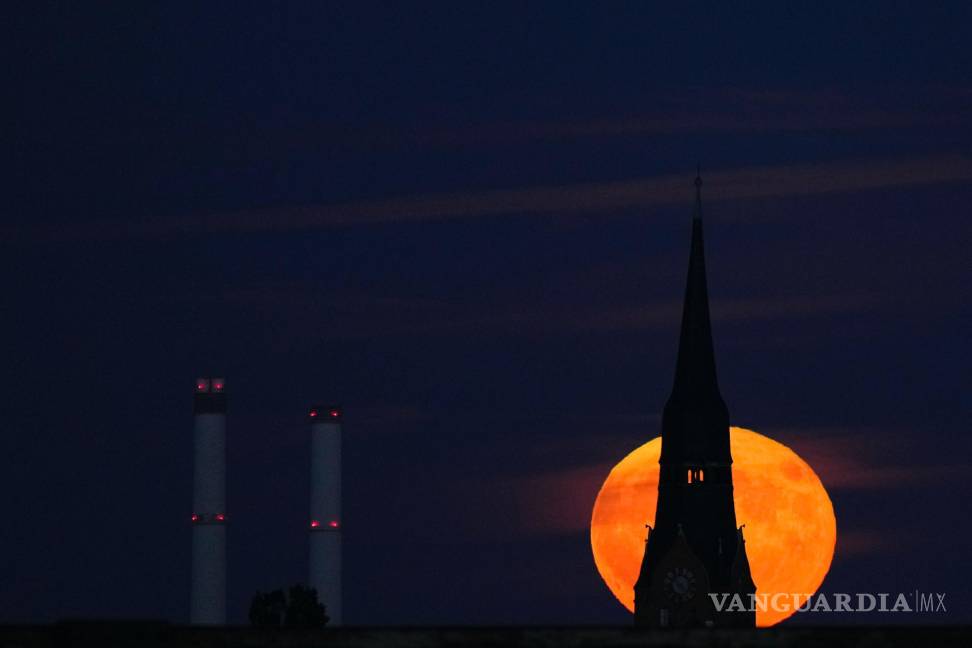 $!La luna llena de fresas se eleva detrás de una iglesia en Berlín, Alemania. Durante un fenómeno conocido como la “ Strawberry Moon”.